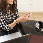 Odnosząca sukcesy kobieta-przedsiębiorczyni z nową firmą online, pracująca w domu w kuchni na swoim laptopie