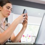 Skoncentrowany bizneswoman texting na telefonie