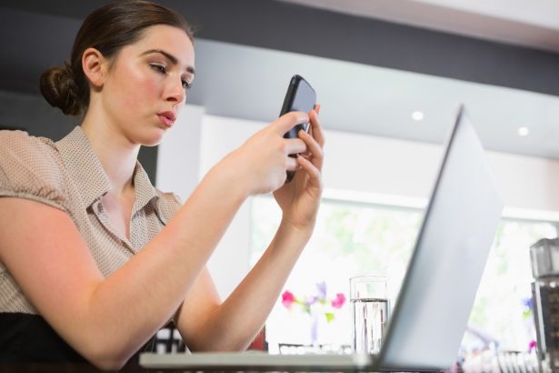 Skoncentrowany bizneswoman texting na telefonie