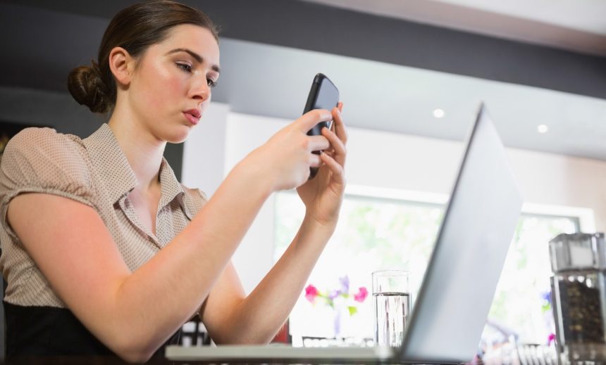 Skoncentrowany bizneswoman texting na telefonie