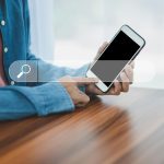 Mężczyzna korzystający z wyszukiwania w smartfonie na telefonie komórkowym w Internecie