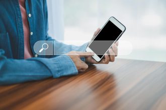 Mężczyzna korzystający z wyszukiwania w smartfonie na telefonie komórkowym w Internecie