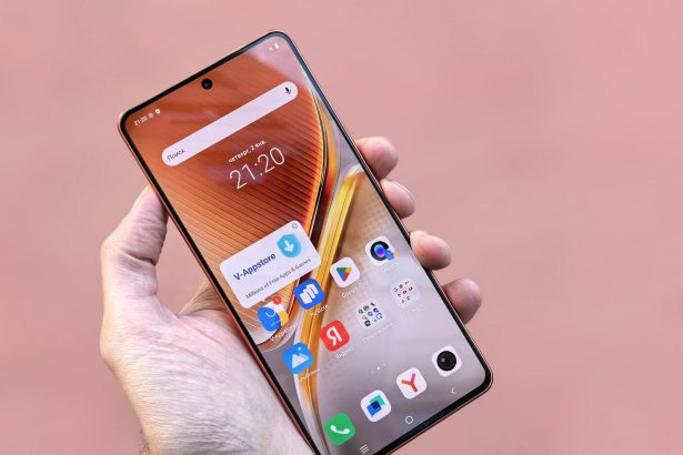 A person holding a smartphone displaying various apps on a pink background. Ideal for technology themes.