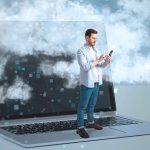 Abstrakcyjny obraz biznesmena stojącego na klawiaturze laptopa i używającego telefonu komórkowego na komputerze stacjonarnym z chmurami Praca zdalna Technologia VR i koncepcja innowacji