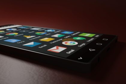 Close-up of a smartphone displaying various app icons in a low-light setting.