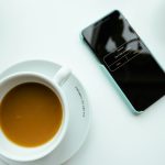 a cup of coffee and a cell phone