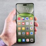 A person is holding a phone displaying its home screen.