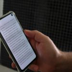 a person holding a smart phone with a book on the screen