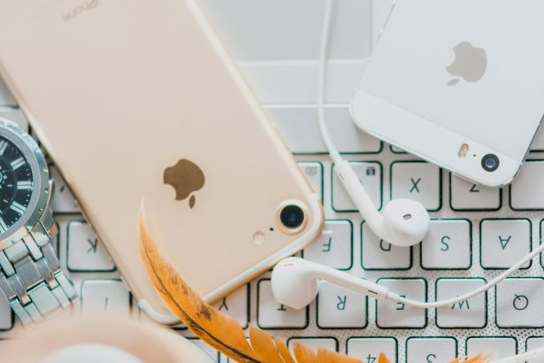 gold iPhone 7 beside white Apple EarPods and silver iPhone 5s