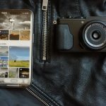 Smartphone and camera on black leather