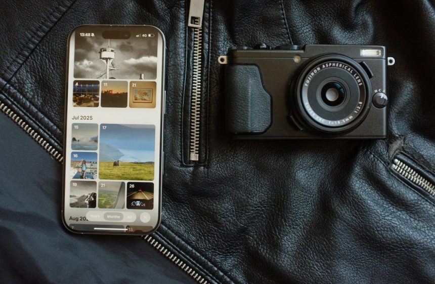 Smartphone and camera on black leather