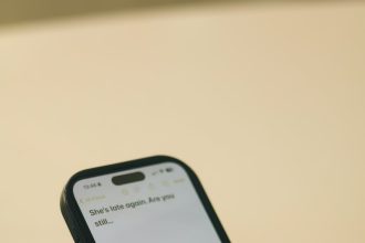 Hands typing on a smartphone with a message on screen.