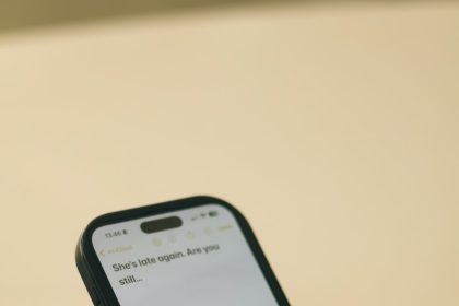 Hands typing on a smartphone with a message on screen.