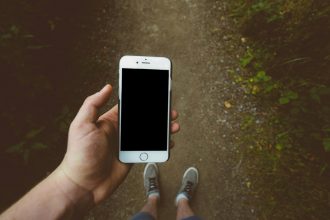 person holding silver iPhone 6 with black case