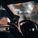 a person sitting in a car holding a cell phone