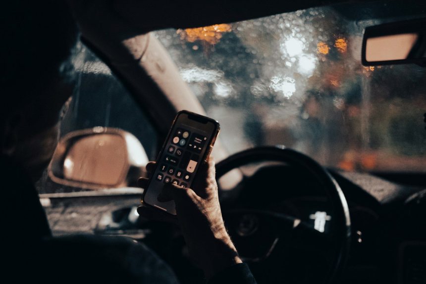 a person sitting in a car holding a cell phone